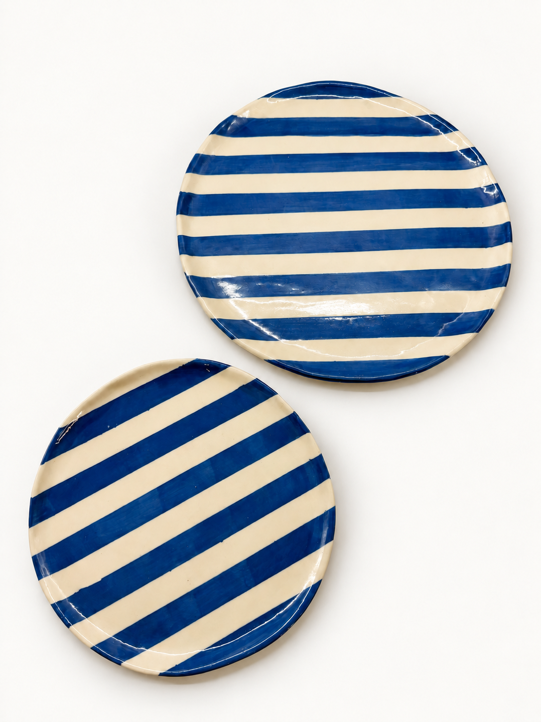 Top view of handmade cobalt stripe dinner and side plate set