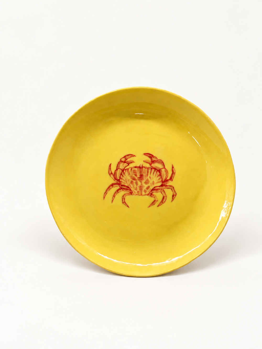 Angled view of butter-yellow handmade crab serving plate