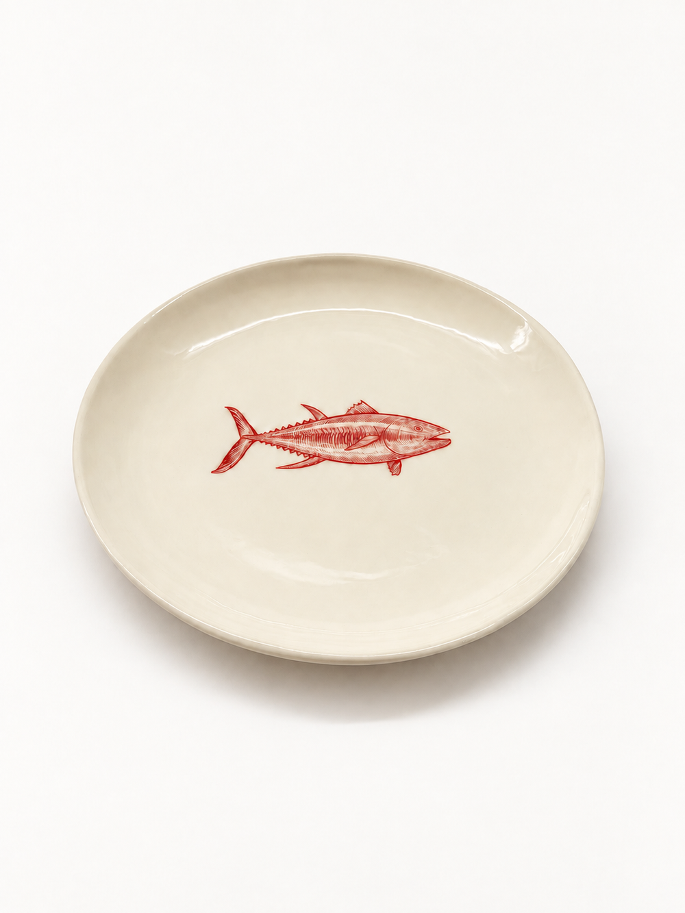Angled view of handmade ivory fish plate, approximately 27 cm