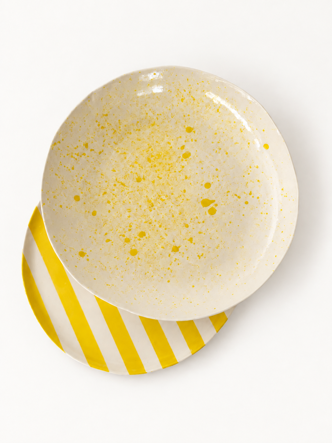 Yellow-speckled serving bowl with yellow-striped serving plate